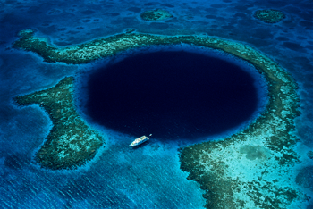 Great Blue Hole v Belizeju je 40 metrov globoka vrtača temno modre barve, ki je v lepem kontrastu z zelenkastomodro barvo karibskega morja. Foto: lonelyplanet.com